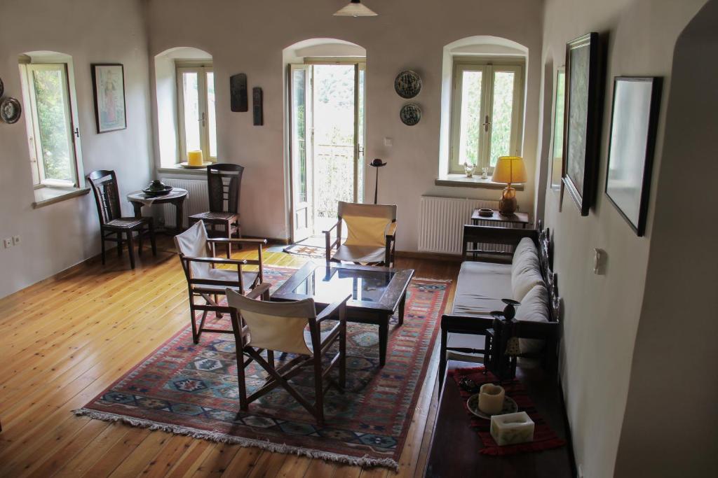 een woonkamer met een bank en een tafel en stoelen bij The Stonehouse in Stemnitsa