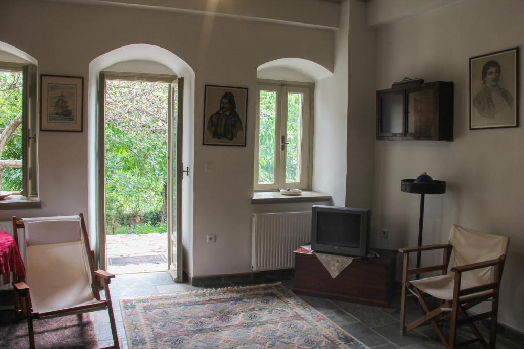 salon z telewizorem i dwoma oknami w obiekcie The Stonehouse w mieście Stemnitsa