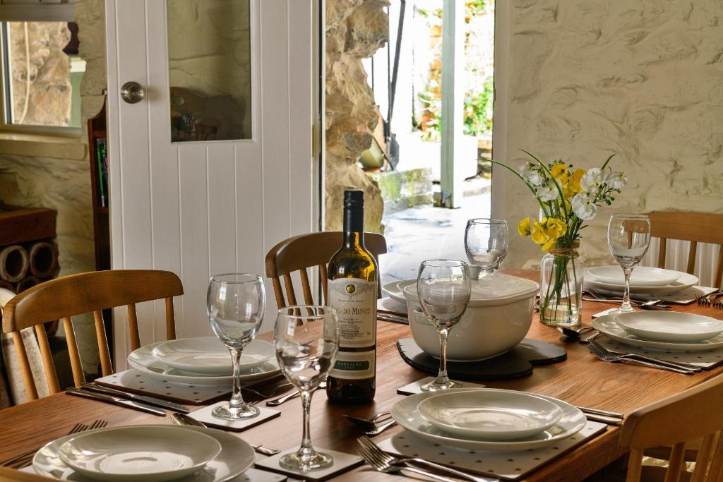 ドルゲラウにあるFinest Retreats - Hope House - Ty Gobaithのワイン1本とグラスをテーブルに用意しています。