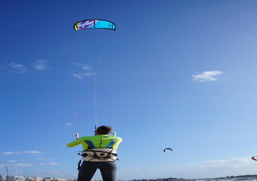a man flying a kite on the beach at Hotel et Studios Le Marina Baie de La Baule in Pornichet