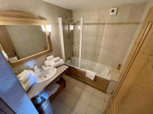 a bathroom with a sink and a bath tub at Le Vancouver in La Plagne