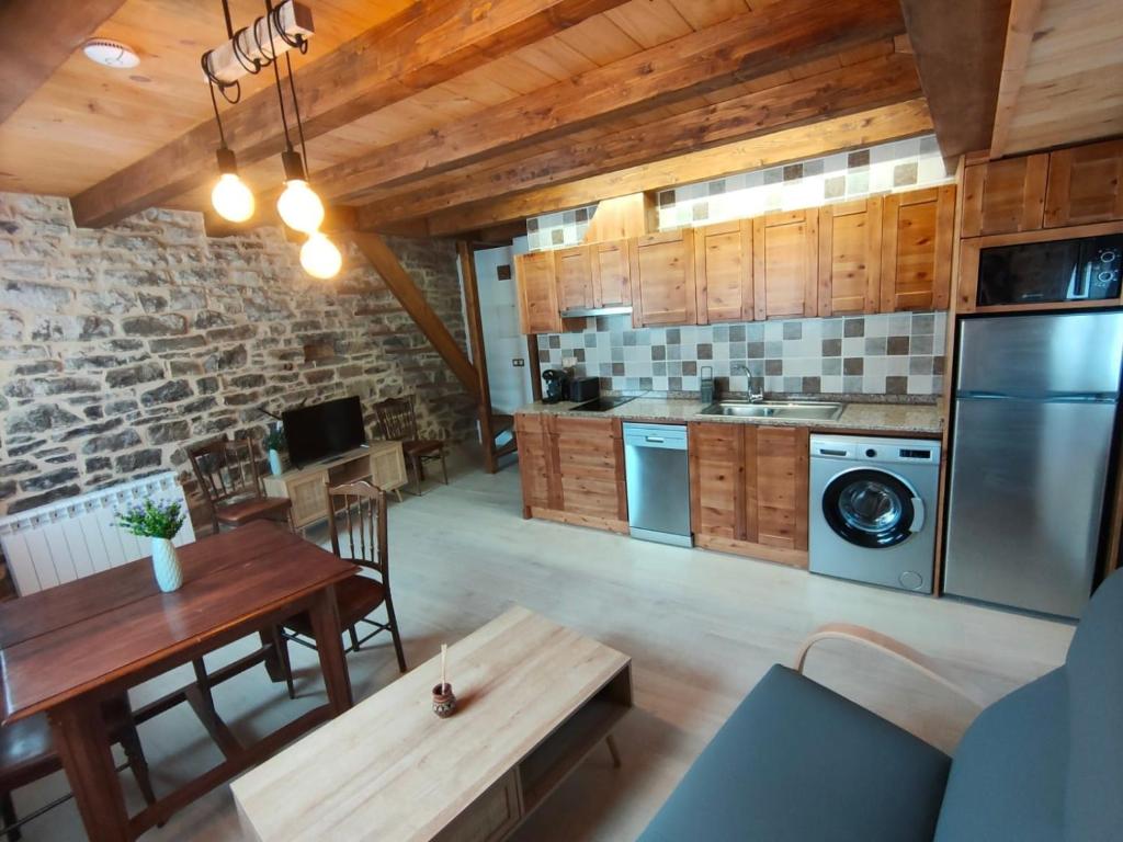 a kitchen with wooden cabinets and a wooden table at CASA PESCA VERA in Senegüé