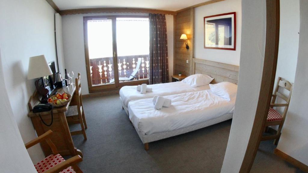 a hotel room with a bed and a window at Le Vancouver in La Plagne