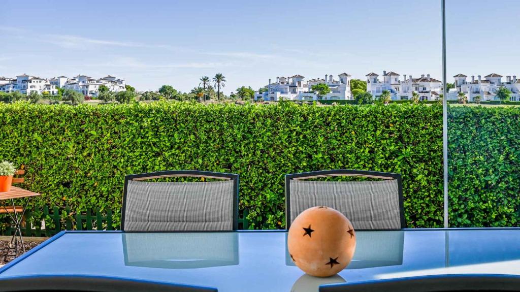 un tavolo blu con due sedie e un tavolo con un'arancia sopra di Stunning Townhouse with wonderful views on La Torre Golf Resort 2 Bed 2 Bathroom LA228LT a Torre-Pacheco