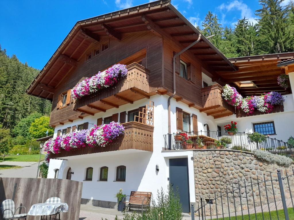 een huis met bloemen op de balkons bij Haus Kohler Bernhard in Nova Levante
