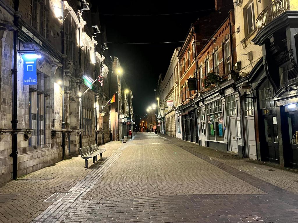 an empty city street at night with a bench at Top Floor in Lincoln