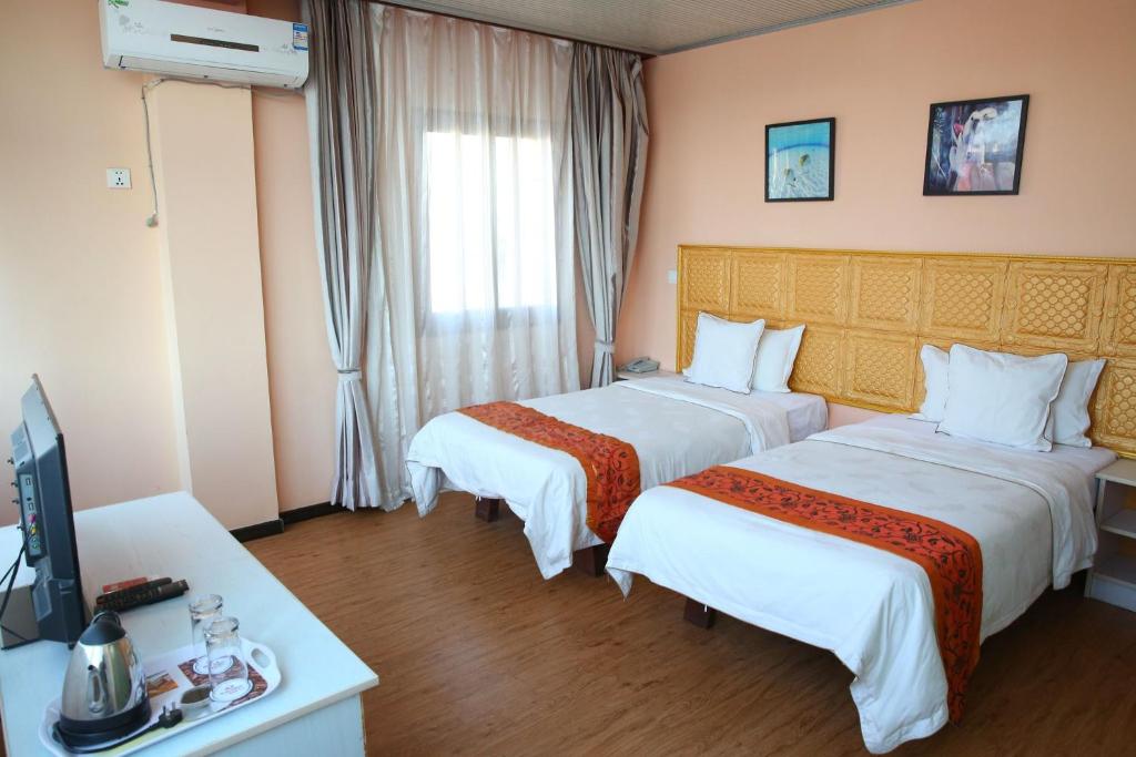 a hotel room with two beds and a television at Hotel Cristal Madagascar in Antananarivo