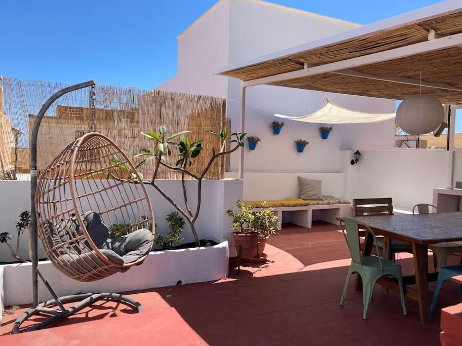 um pátio com uma cadeira de vime e uma mesa em Andalusian house - Beach at 85 meters - Terrace em Málaga