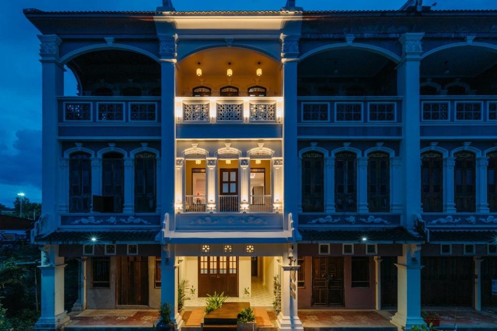 - un grand bâtiment bleu avec balcon la nuit dans l'établissement Botan Boutique Hotel, à Patong Beach