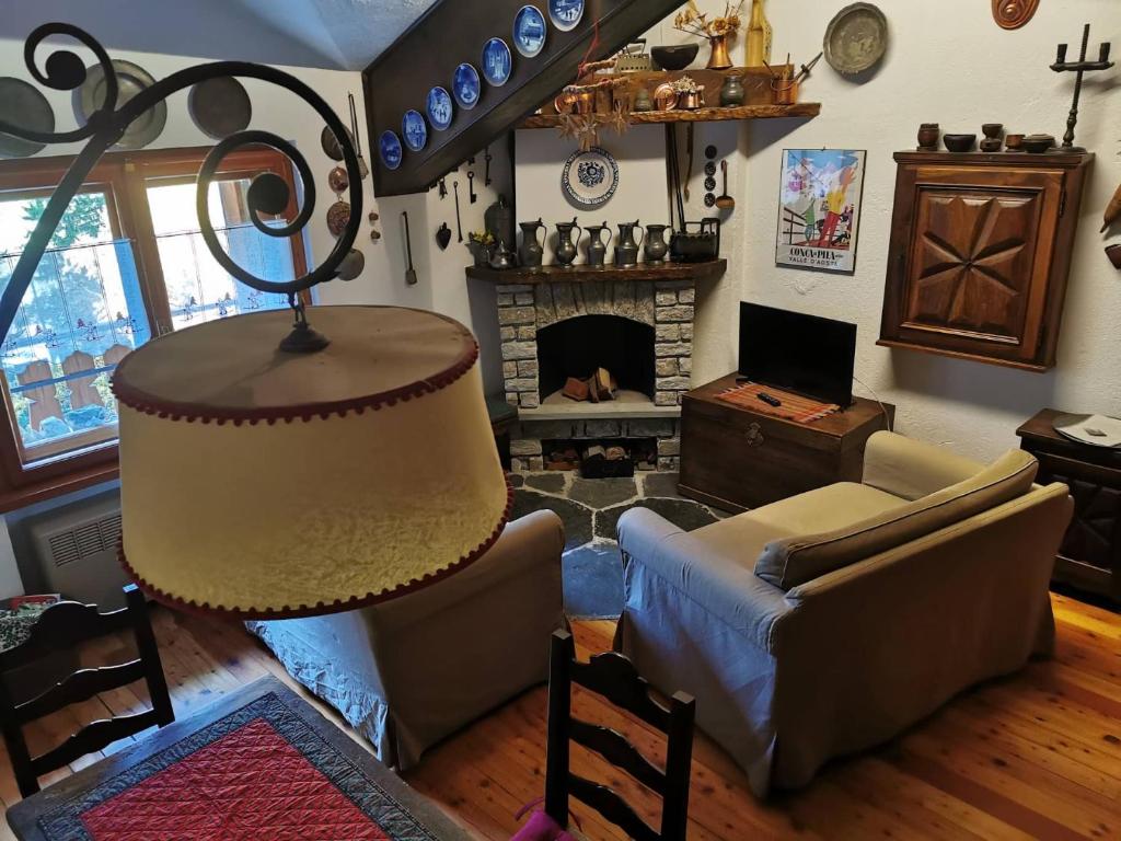 sala de estar con sofá y chimenea en Cogne come una volta, en Cogne