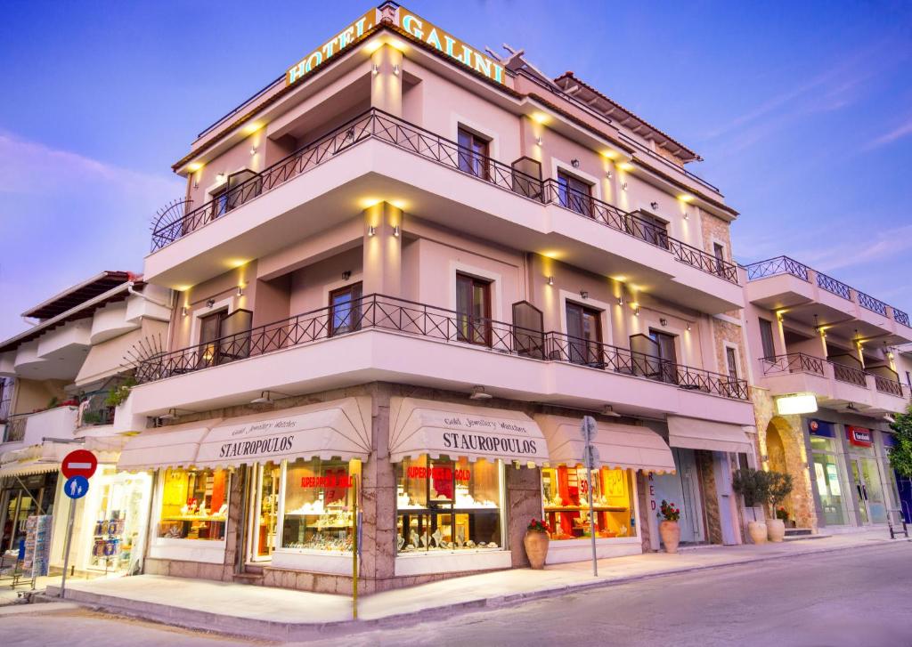 een hoog wit gebouw op de hoek van een straat bij Hotel Galini in Limenas