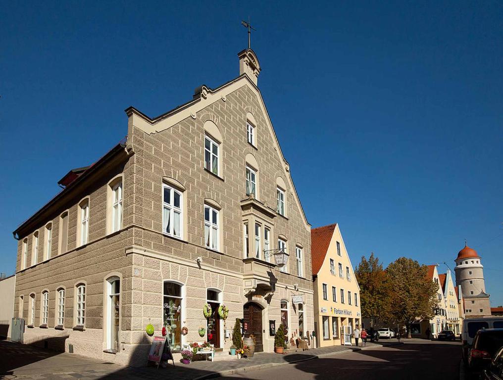 a large brick building with a cross on top of it at Weinstube Sinas Brettl in Nördlingen