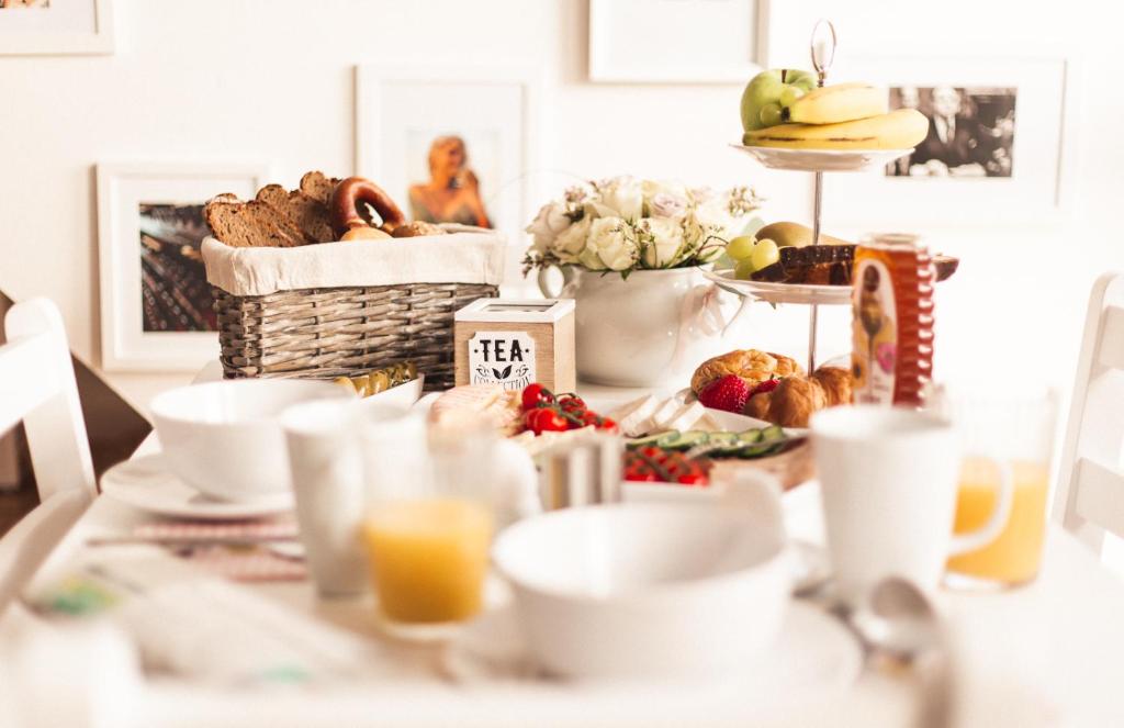 une table avec des aliments pour le petit-déjeuner et du jus d'orange dans l'établissement Pfälzer Herzel, à Neustadt an der Weinstraße