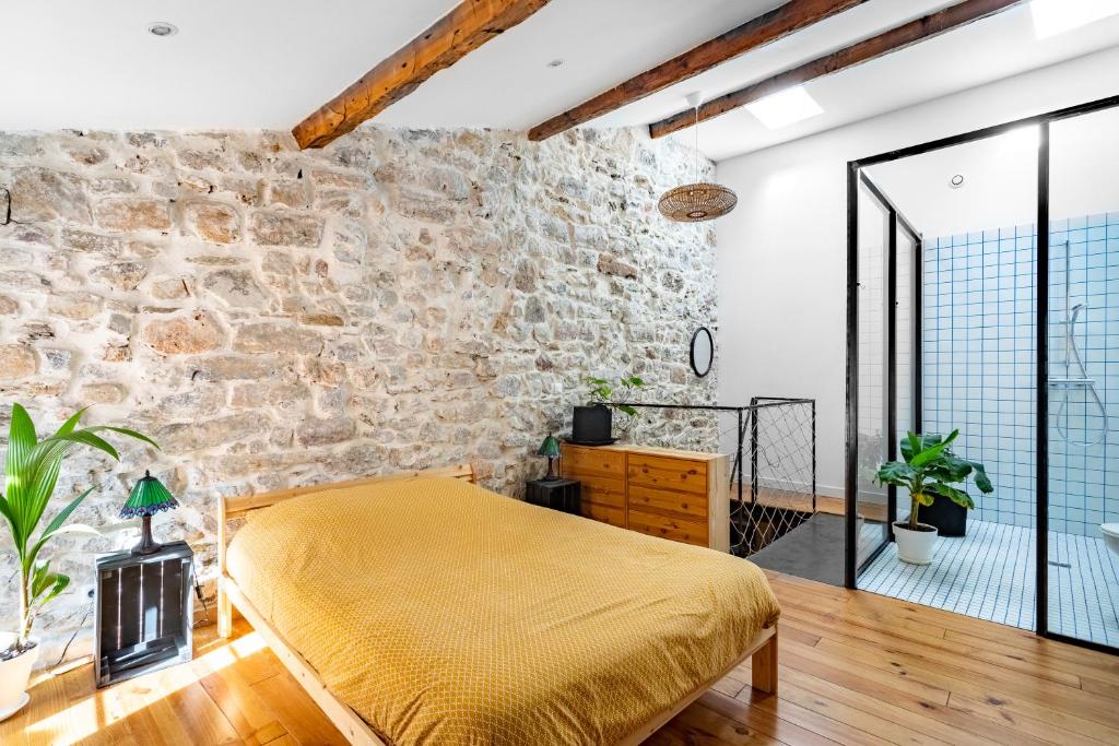 1 dormitorio con pared de piedra y cama amarilla en Singulary House-Loft with AC Downtown - Dodo et Tartine, en Hyères