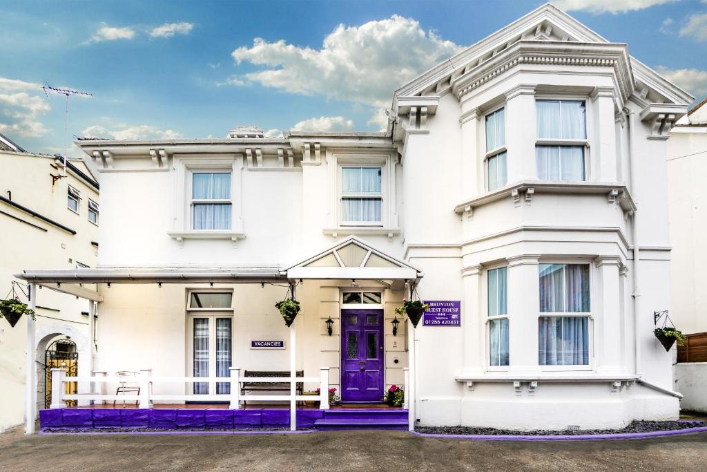 a white house with a purple door at Brunton House Guest House in Clacton-on-Sea