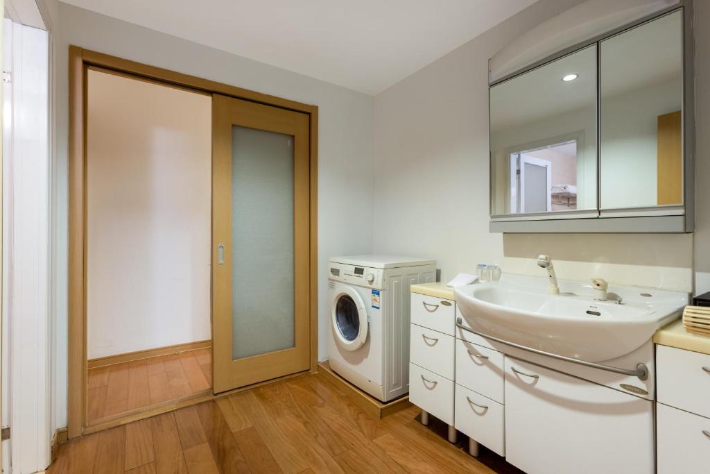 a bathroom with a sink and a washing machine at Belgravia Serviced Residence Wuxi in Wuxi