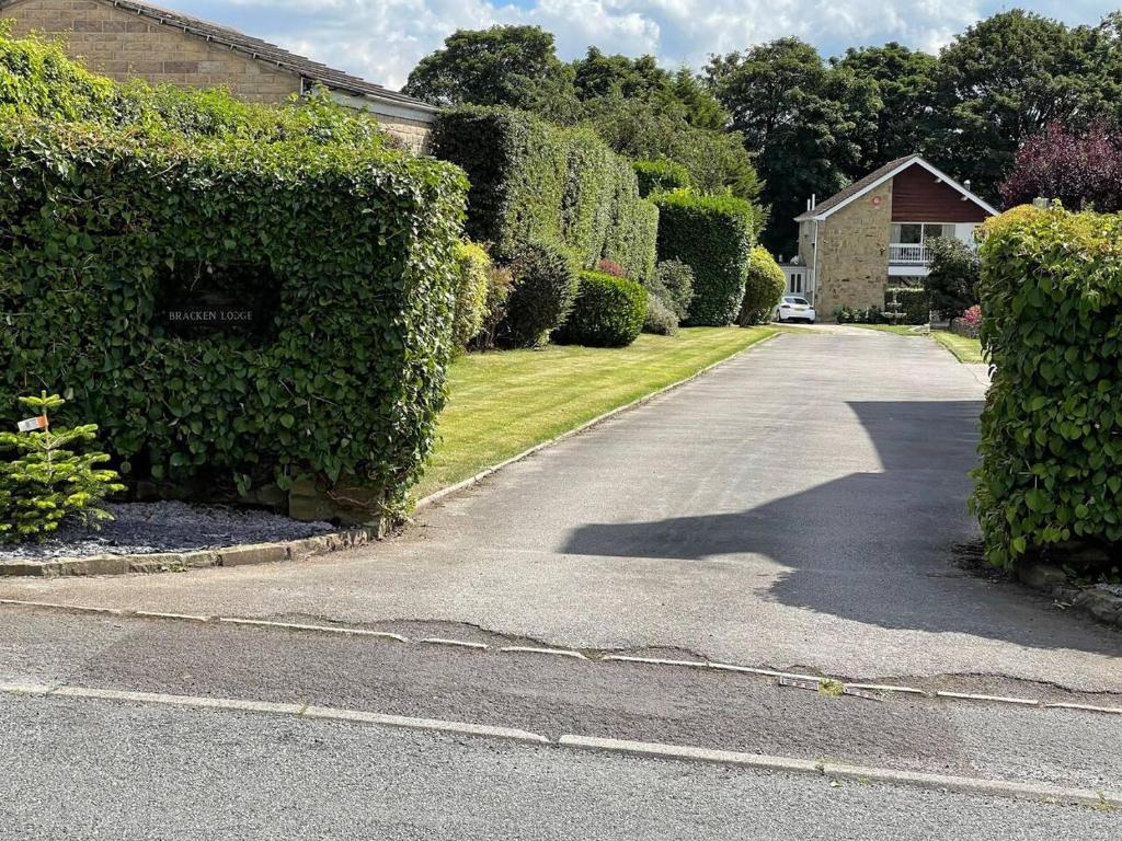 a driveway in a house with a hedge at Immaculate 1-Bed Studio with outside patio in Brighouse
