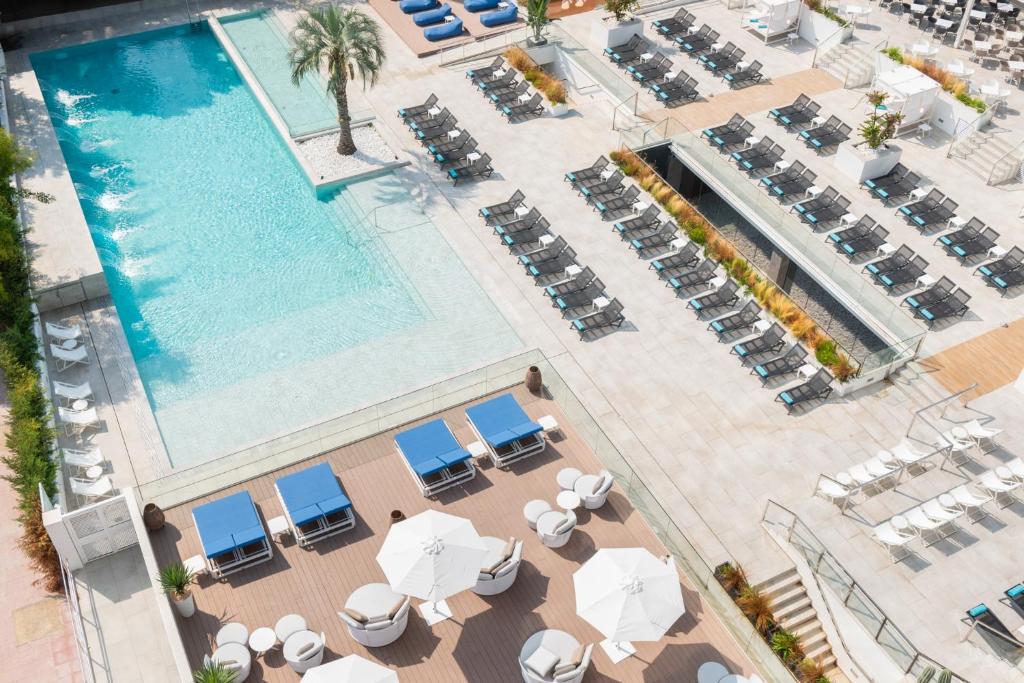 an overhead view of a pool with chairs and umbrellas at L'Azure Hotel 4* Sup in Lloret de Mar