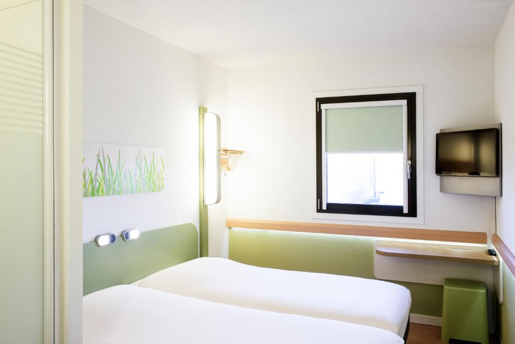 Postel nebo postele na pokoji v ubytování Hotel Ibis Budget Lyon Eurexpo -