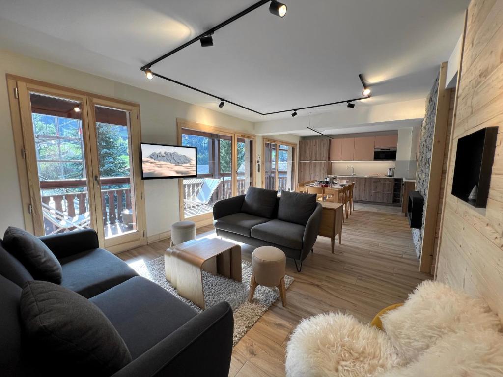 uma sala de estar com dois sofás e uma cozinha em OURS POLAIRE bel appartement village et pistes em La Clusaz