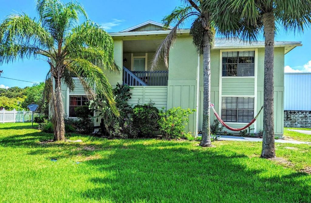 a house with palm trees in front of it at Beach Escape by Casago in Saint Augustine Beach