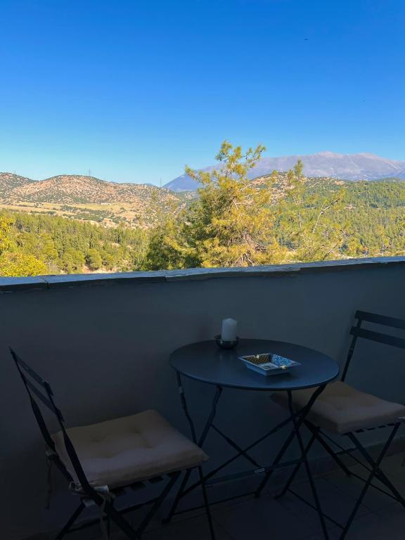 a table and two chairs on a balcony with a view at Villa Kastro Elassona in Elassona