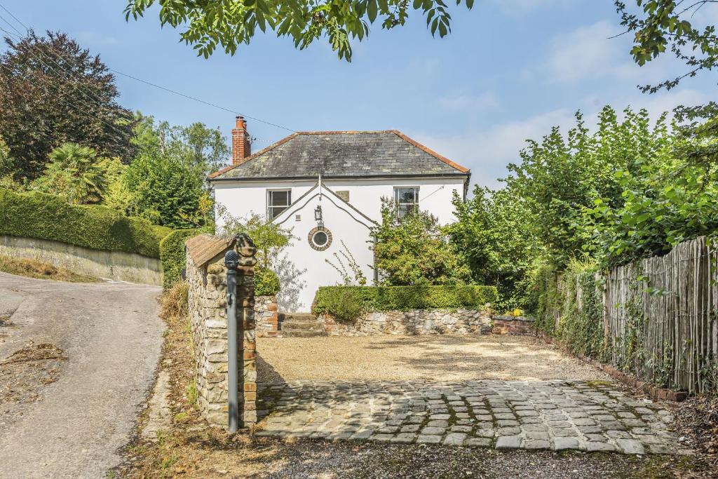 a white house with a fence next to a road at Ryall Hope Cottage in Bridport