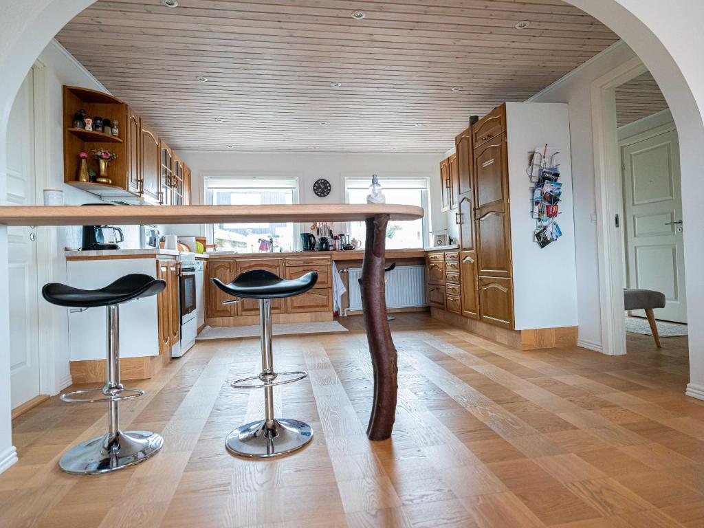 a kitchen with a table and two stools at Marna Guesthouse doubleroom nr.2 in Tórshavn