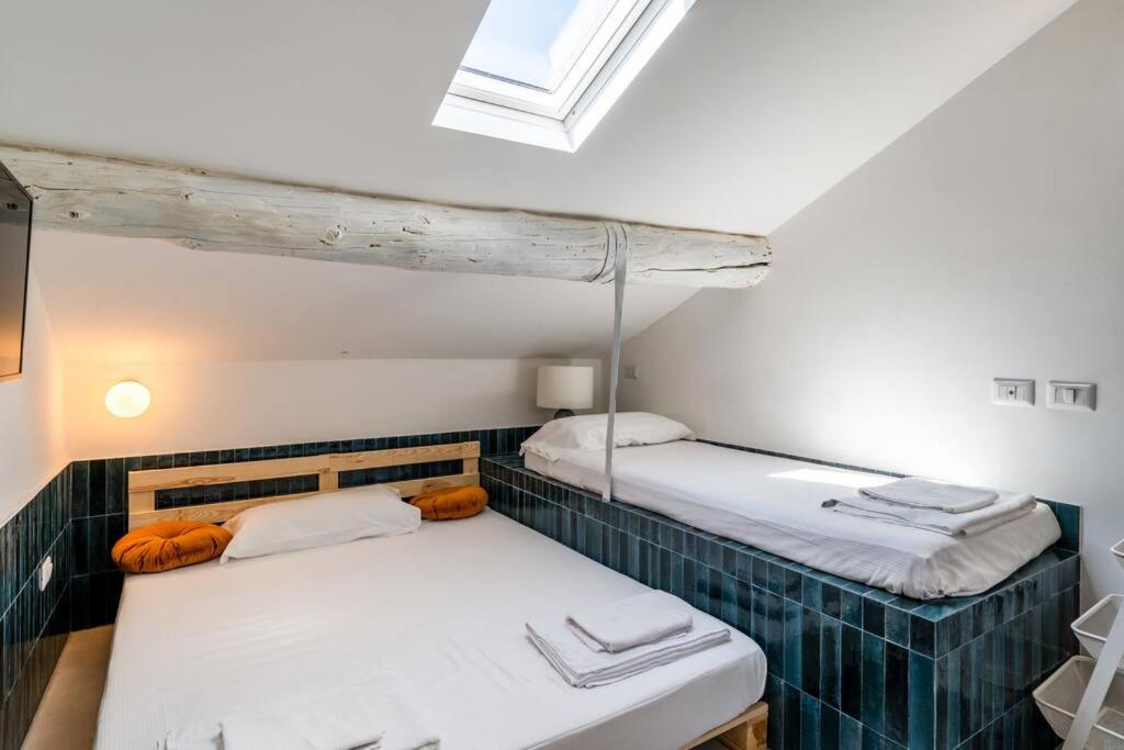 2 Einzelbetten in einem Zimmer mit Fenster in der Unterkunft Easylife - Grazioso monolocale in zona Buenos Aires in Mailand