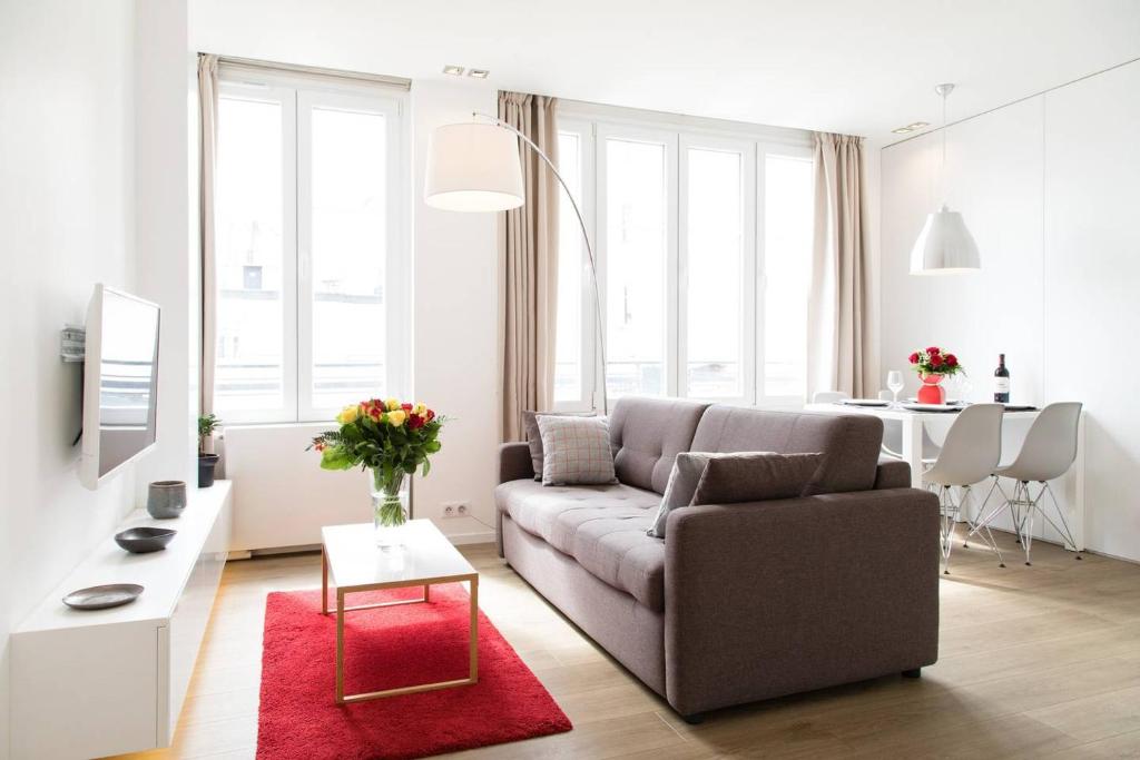 uma sala de estar com um sofá e um tapete vermelho em Arc de Triomphe Apartment em Paris