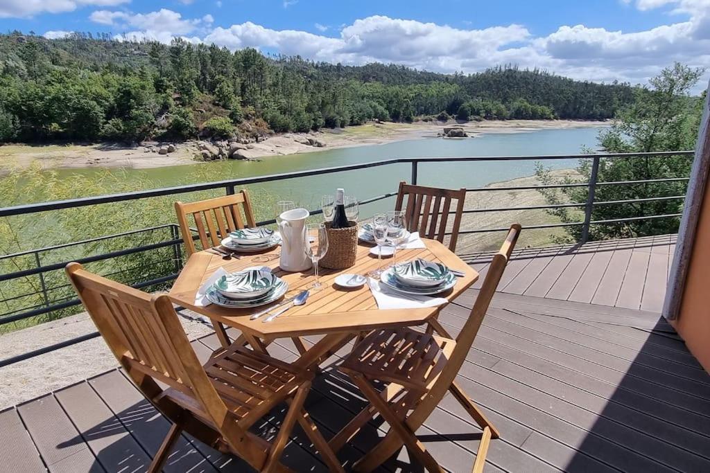 a wooden table on a deck with a view of a river at Casa do Rio in Treixedo