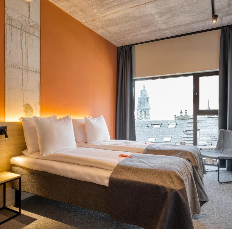 a bedroom with a large bed with a large window at Citybox Antwerp in Antwerp