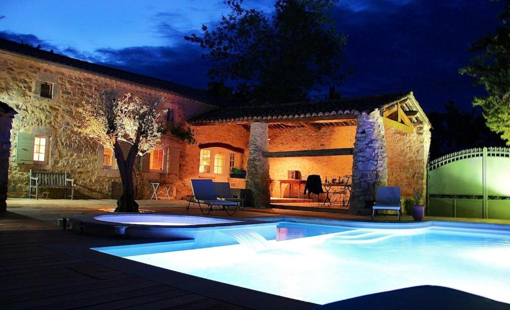 una piscina frente a una casa por la noche en Villa de 3 chambres avec piscine privee jacuzzi et jardin clos a Lussana, en Lussan