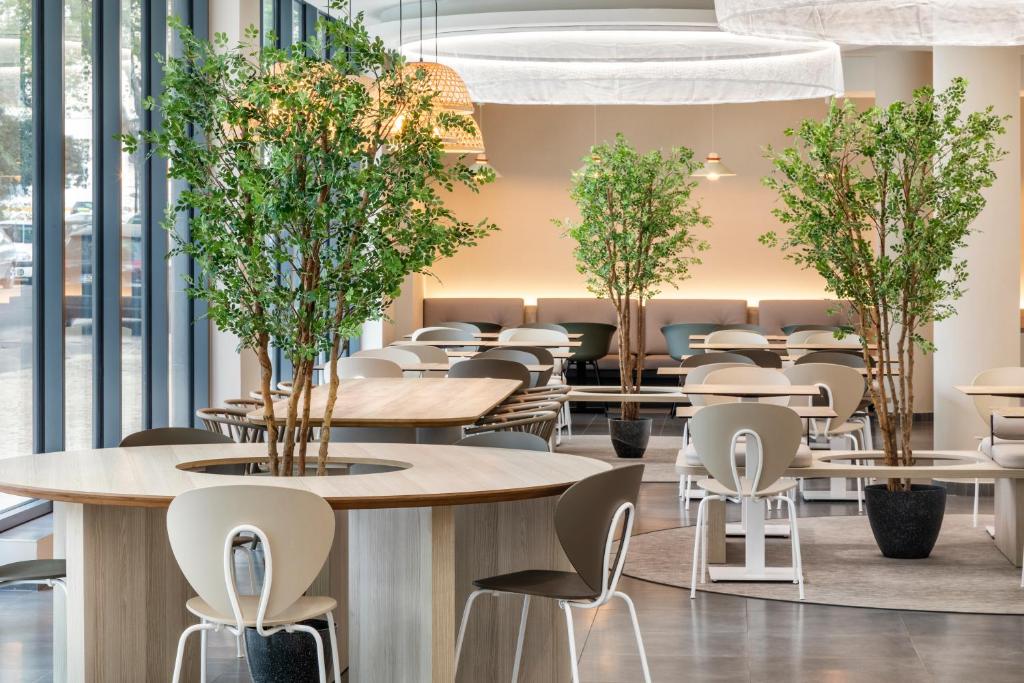 a restaurant with tables and chairs and trees at B&B HOTEL Lisboa Montijo in Montijo