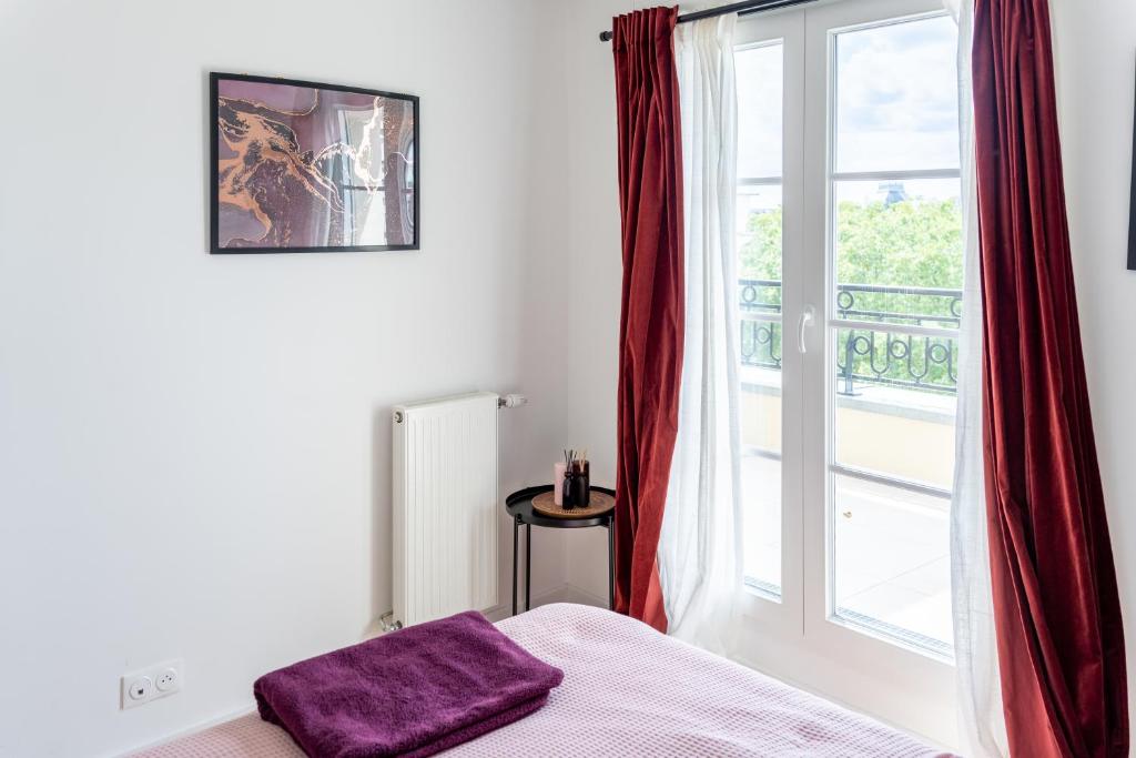 een bed met een paars kussen voor een raam bij Superbe Appartement F4 Puteaux in Puteaux