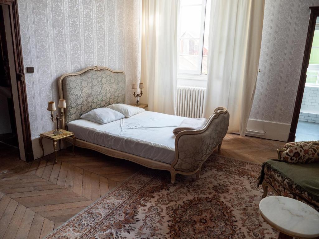 ein Schlafzimmer mit einem Bett, einem Sofa und einem Fenster in der Unterkunft Gamotel in Vitteaux