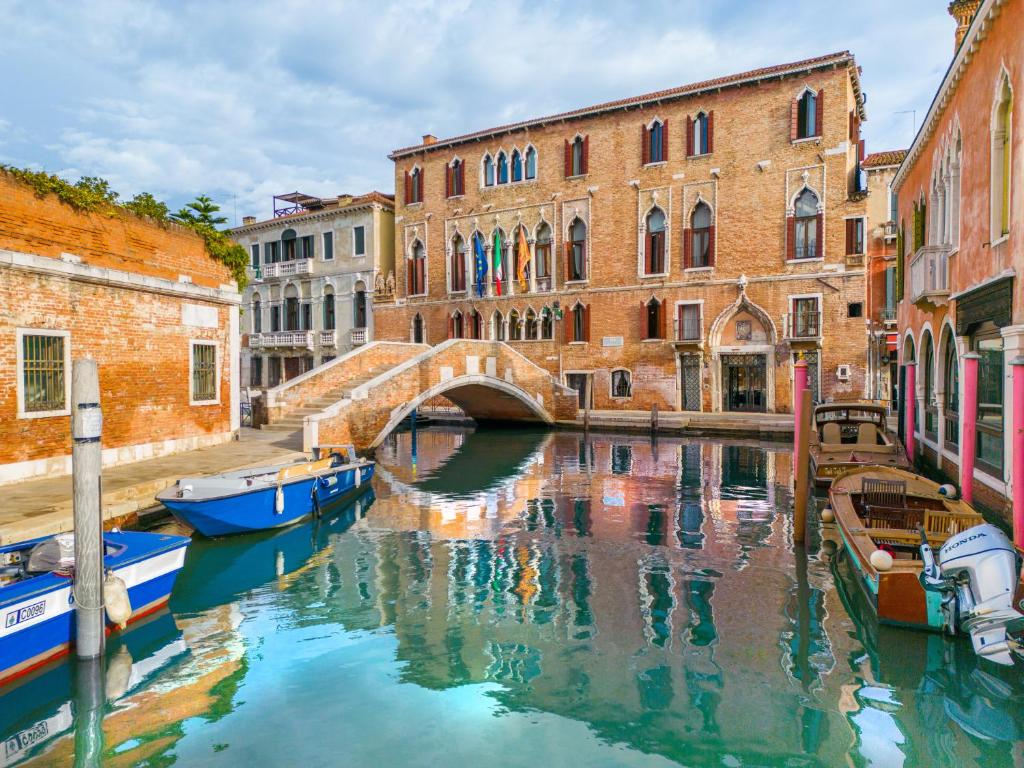 a canal in a city with boats in the water at Palazzo Marcello Hotel Al Sole in Venice