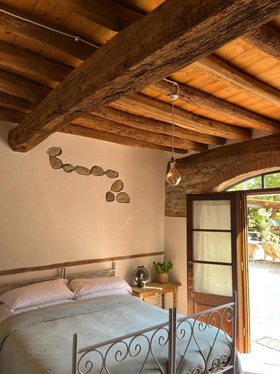 1 dormitorio con cama y techo de madera en Agriturismo Rio Verde, en Sasso Marconi