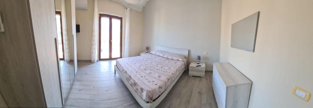 a bedroom with a bed and a hallway with windows at Casa Vacanze La Voce del Mare in Boscoreale