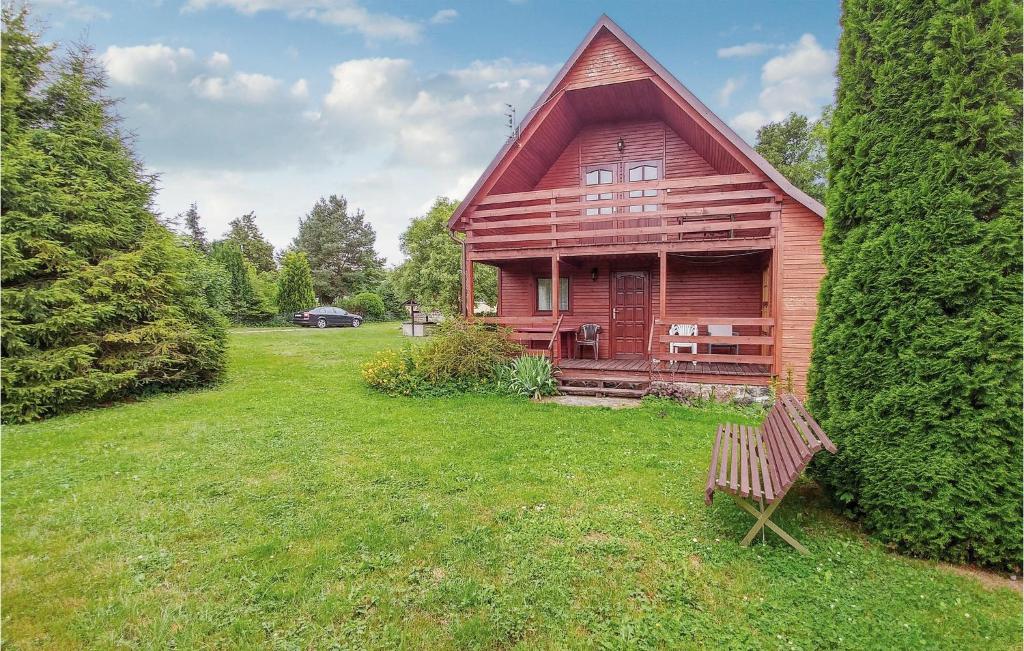 una casa in legno con una panchina in un cortile di Four-Bedroom Holiday Home In Choczewo a Choczewo