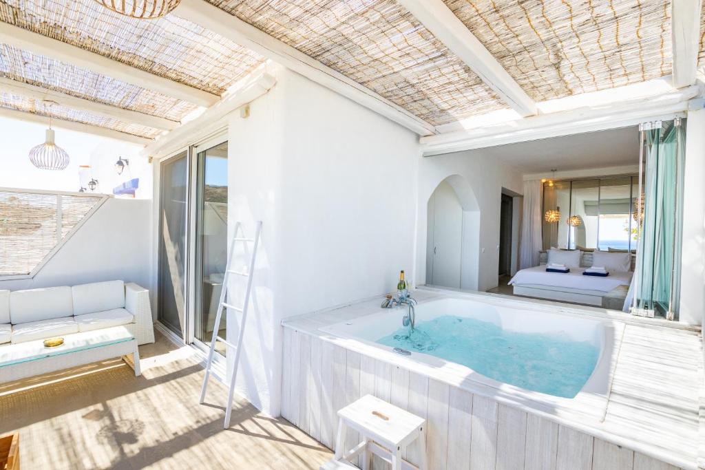 ein Bad mit einer großen Badewanne in einem Zimmer in der Unterkunft Poseidon Blue Gastronomy Hotel in Afiartis