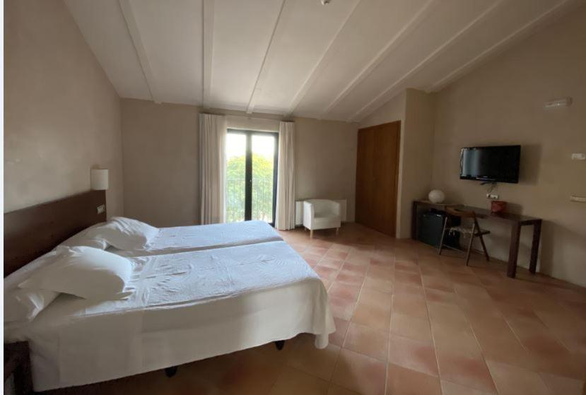 una camera con letto bianco e TV di Hotel Rural Casa Pernías a Moratalla