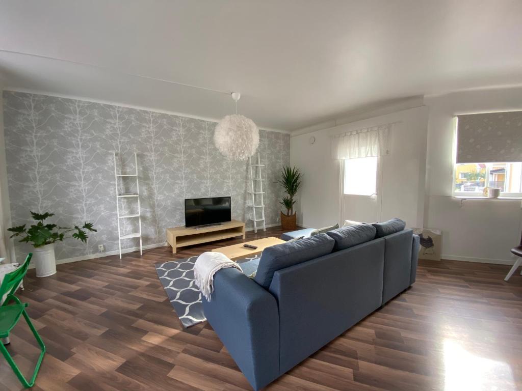 sala de estar con sofá azul y TV en Welcome to two rooms apartment in central Tibro en Tibro