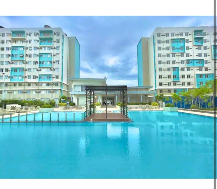a large swimming pool in front of a large building at Condotel DC MARINA SPATIAL FELINVEST in Dumaguete