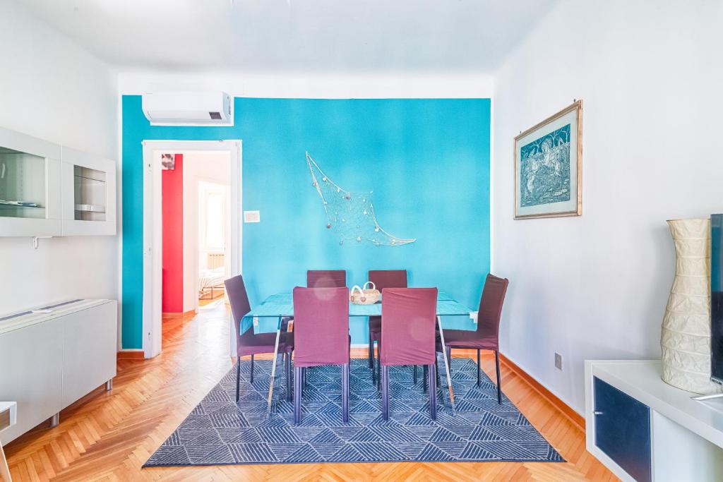 a dining room with a blue table and pink chairs at JJ's Place in Trieste