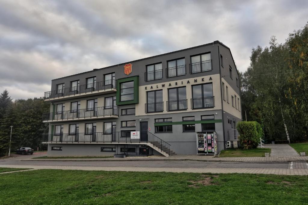 a large gray building on a street at Pawilon Sportowo Turystyczny Kalwarianka in Kalwaria Zebrzydowska