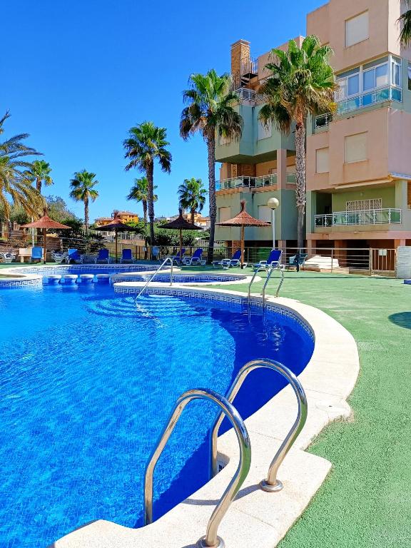 a swimming pool at a resort with palm trees at Cala Azul -7909 in Cabo de Palos