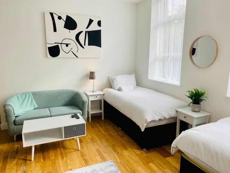 un soggiorno con divano e letto di Midland Apartment- Studio a Leicester