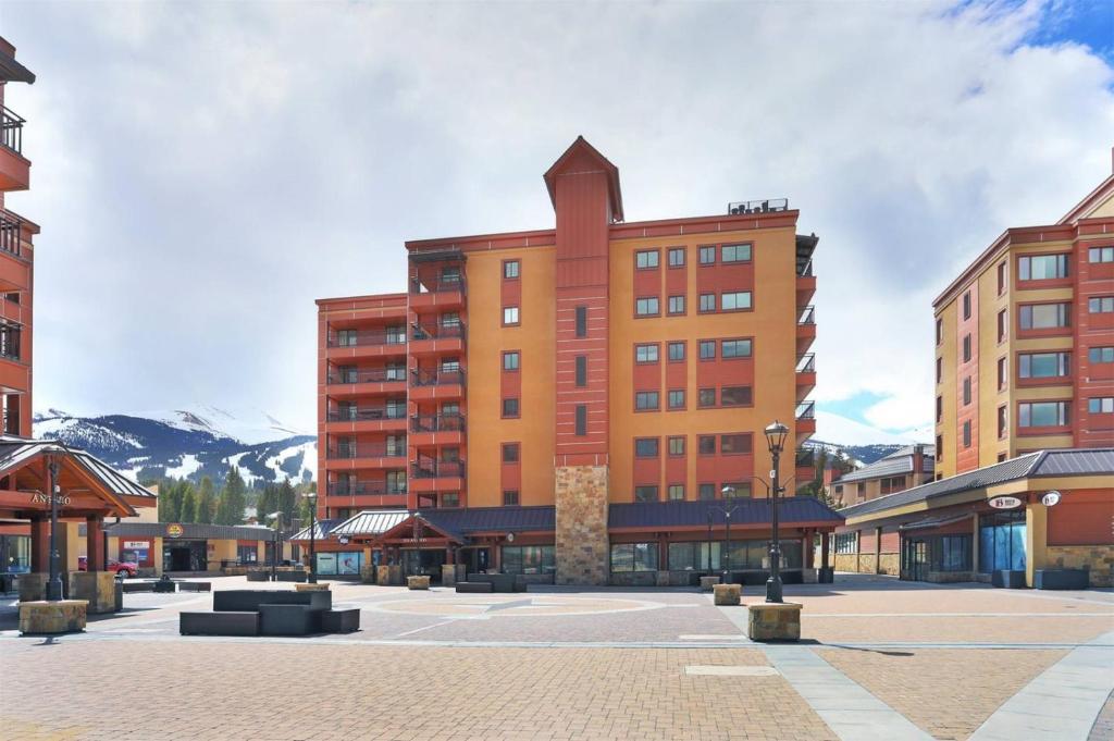 a large building with mountains in the background at 1 Bedroom Ski In, Ski Out Mountain Vacation Rental Located Next To Historic Main Street In Downtown Breckenridge in Breckenridge