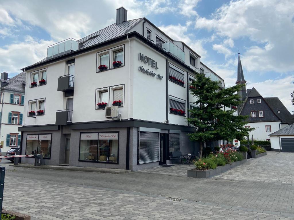 a white building with a sign on the side of it at Hotel Hessischer Hof in Butzbach